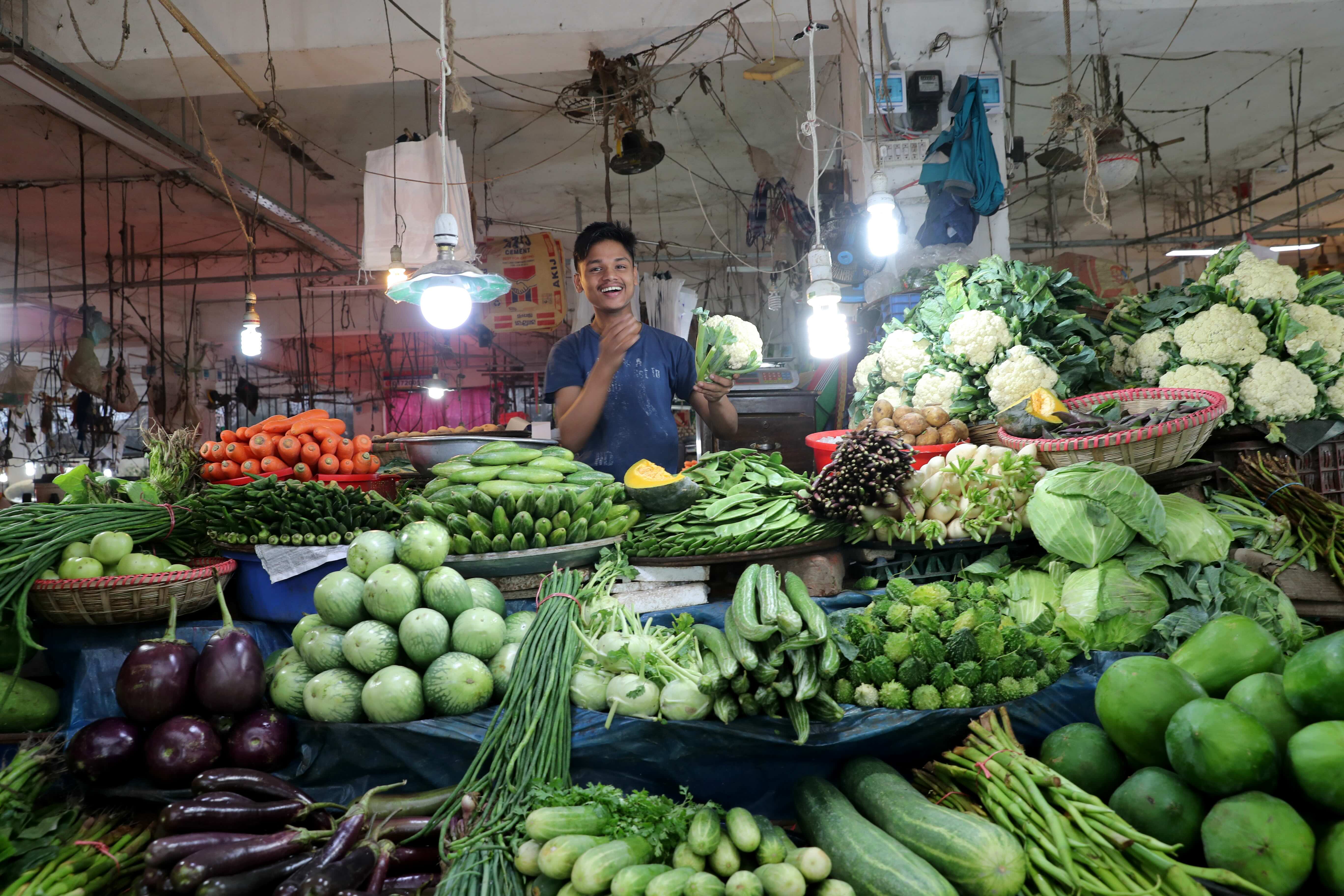 A young man selling vegetables and fruits