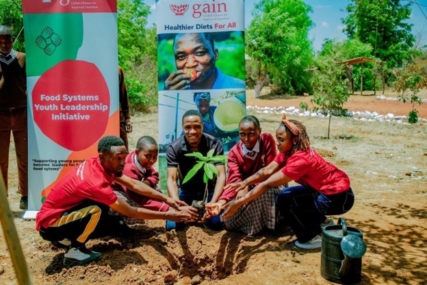Young changemakers taking part in a tree-planting activity in Tanzania