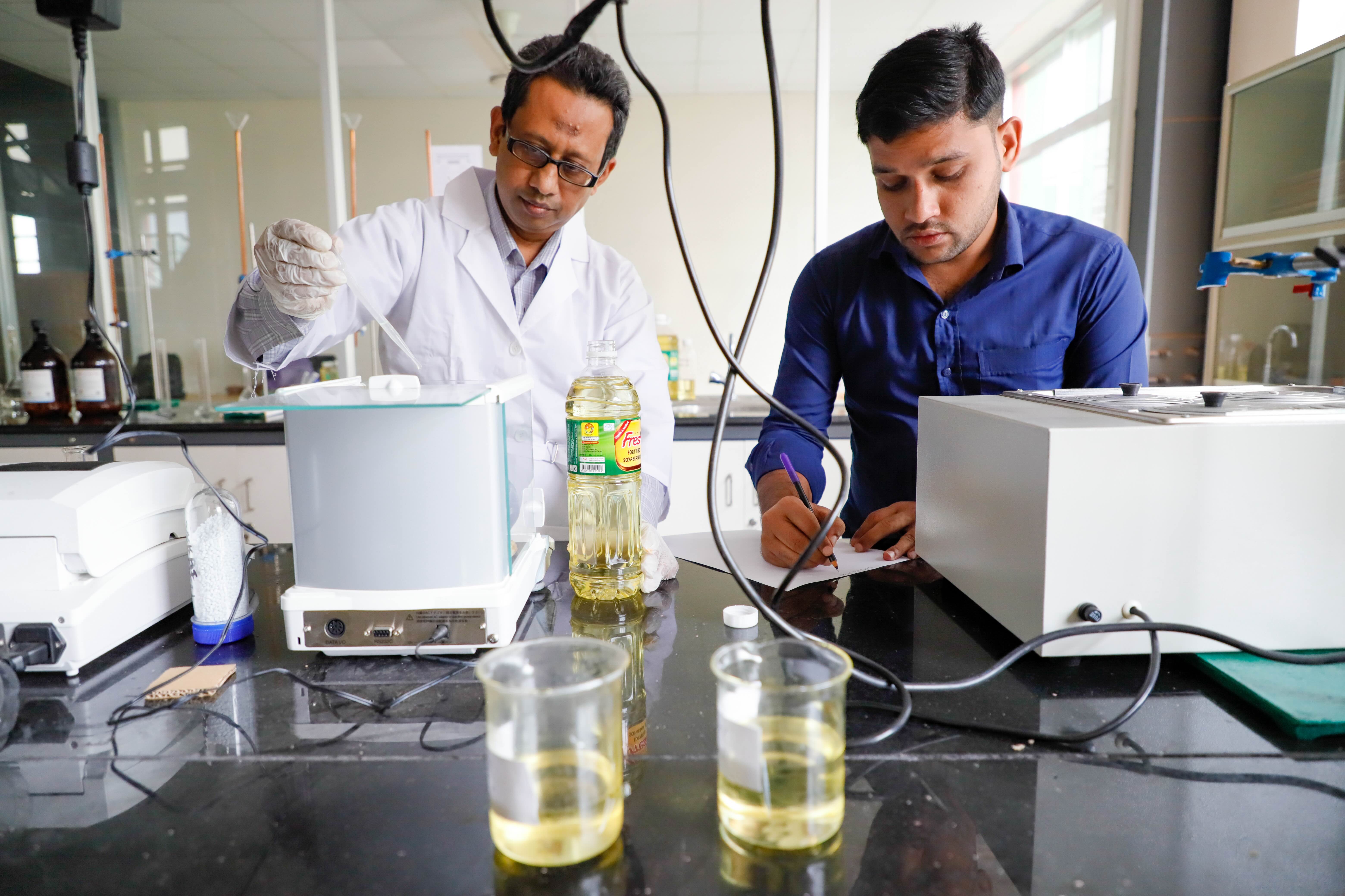 Two men testing oil