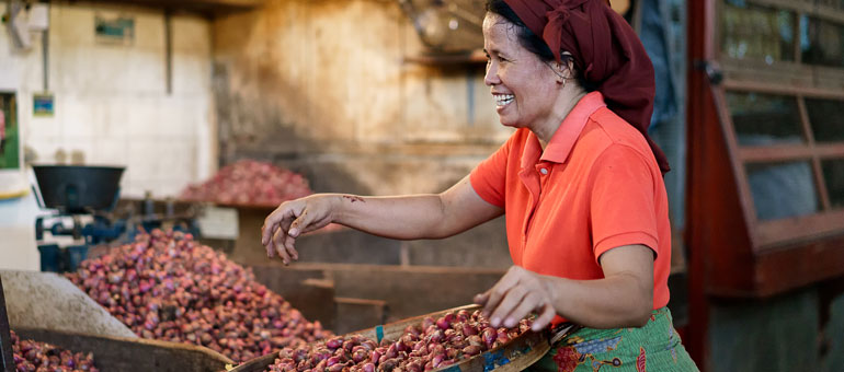 Indonesian lady sorting onions 