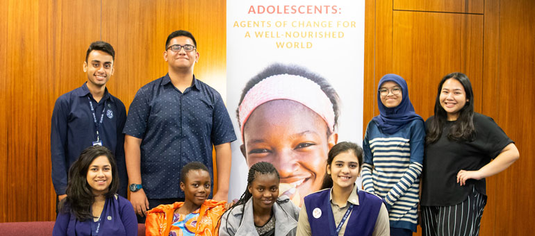 Adolescents in front of banner