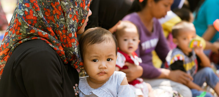 baby-looking-at-the-camera-in-the-mothers-arms