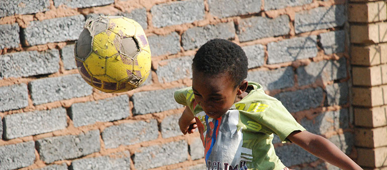 Boy playing with ball in a courtyard in Africa