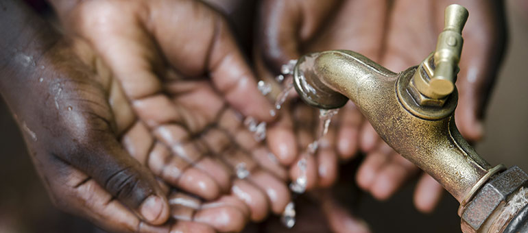 Hands getting water from tap