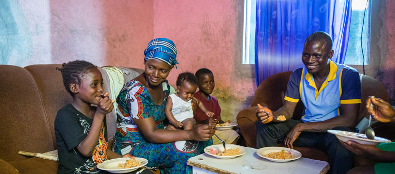 Family sitting together smiling and eating