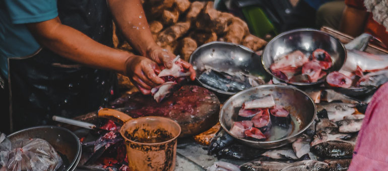 Shot of man hands chopping raw fish in a market