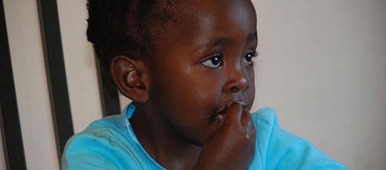 Little girl eating with her hands in Africa