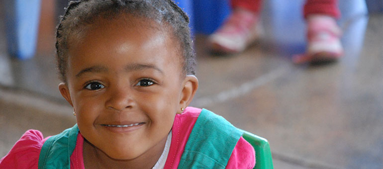 Little school girl in South Africa looks at the camera and smiles