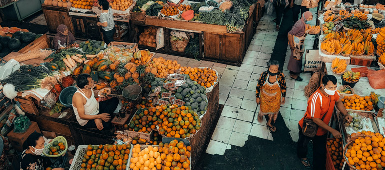 People in the market wearing masks and walking down