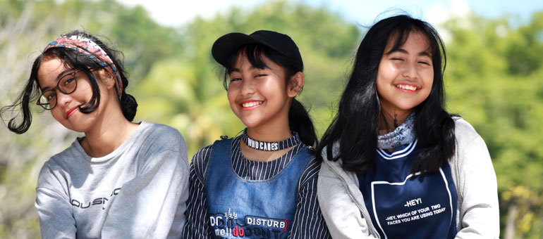 Three adolescents smiling in Indonesia