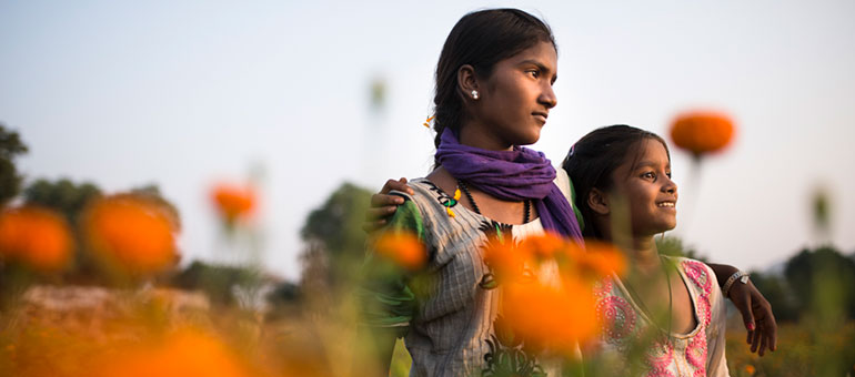 Two girls in a dandelions field in Rajasthan, India 