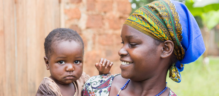 Woman holding baby playing in with her necklace