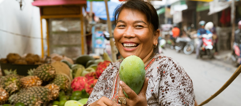 Woman smiling holding fruit