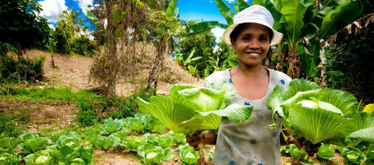 Woman holding lettuce and smiling
