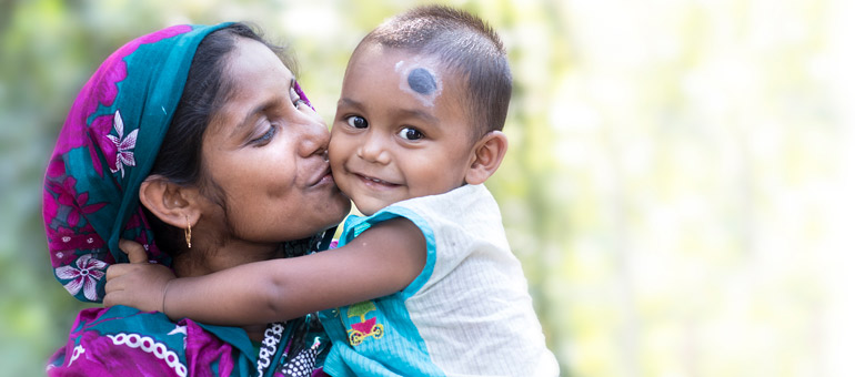 Woman kissing baby cheek in Bangladesh