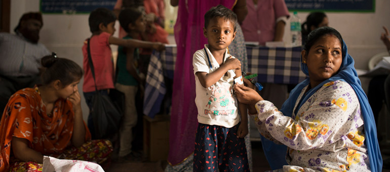 Woman measuring kid arm in India