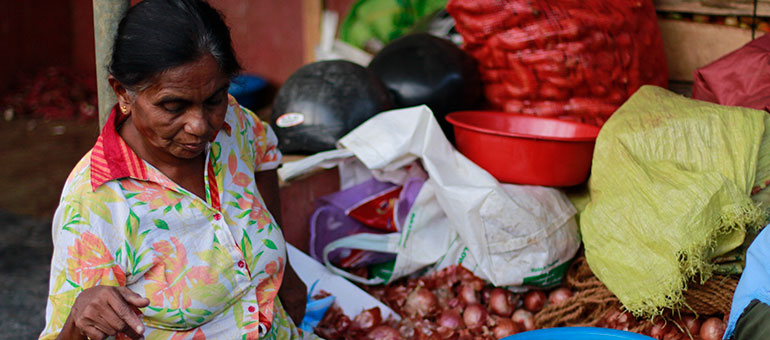 Woman weighting onions in a market in Sri Lanka