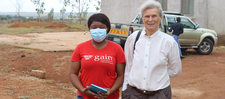 Woman with red tshirt standing next to woman in white shirt