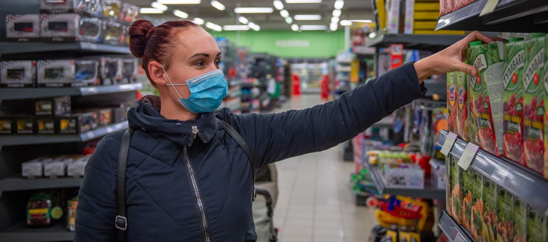 young woman shopping for food with mask