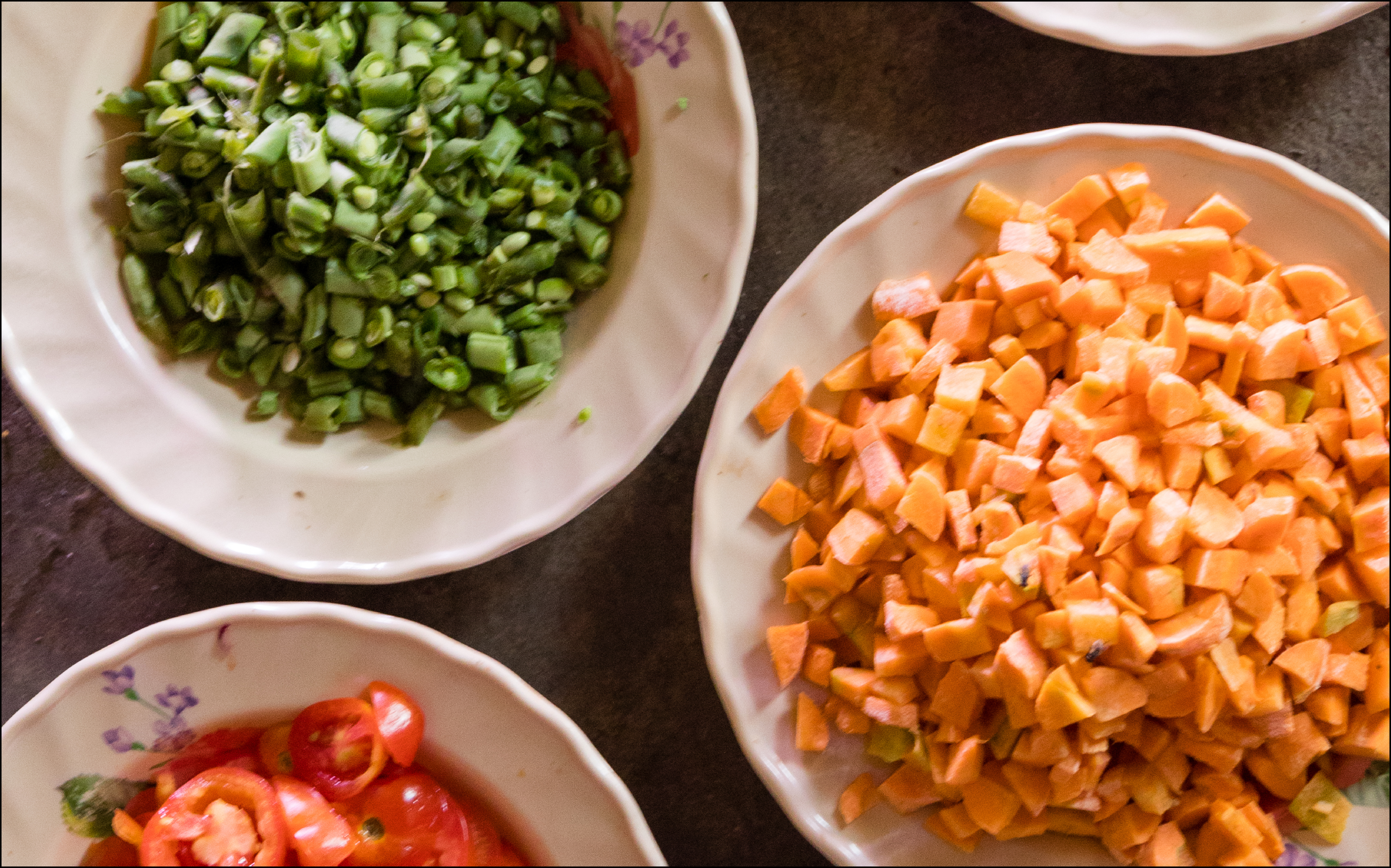 Sliced onions, carrots, tomatoes in bowls