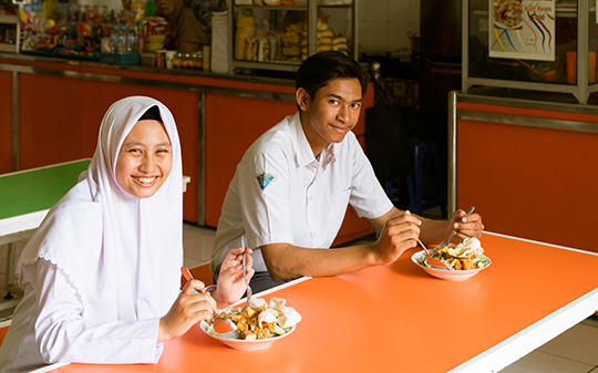 Two adolescents having a meal in school in Surabaya Indonesia