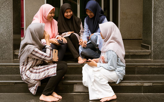 A group of adolescents in Indonesia sitting and smiling 