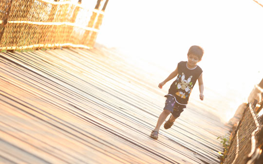 Little child running on a bridge in Bangladesh