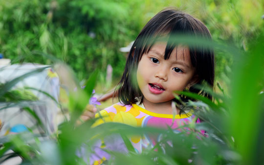 Little girl in green grass smiling