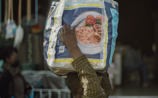 Man carrying a bag of food on the head