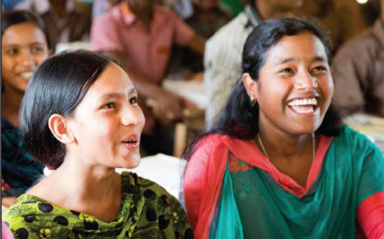 Two smiling girls in a classroom in Bangladesh