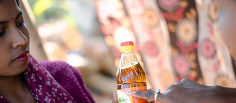 Two women looking at a bottle of oil