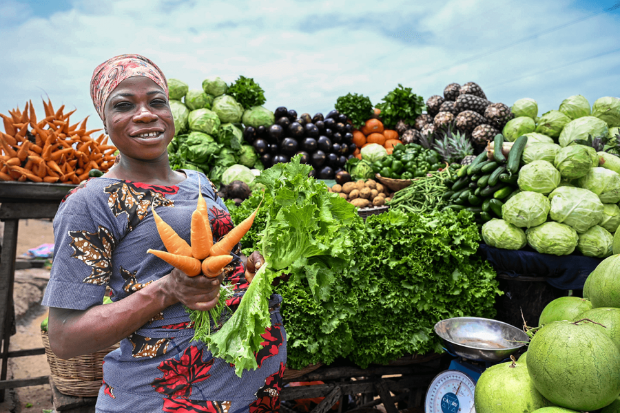 vendor in front of their fruits and vegetables stall
