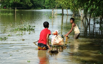 Two young boys pulling a load in high floods
