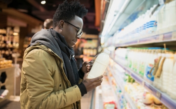 African man checking food labels in supermarket African man checking food labels in supermarket