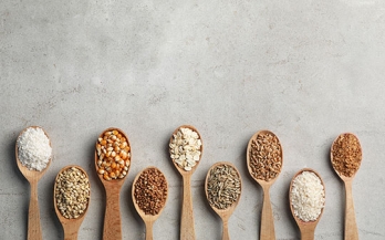 Wooden spoons holding different grains