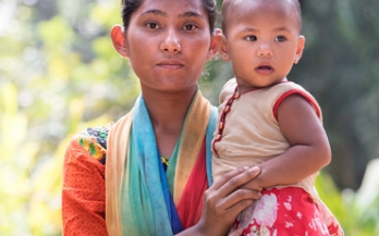 Adolescent girl holding a baby and looking in the camera in Bangladesh Adolescent girl holding a baby and looking in the camera in Bangladesh