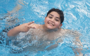 Child swimming in the pool and smiling