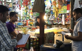 Three men standing up and taking notes at the market Three men standing up and taking notes at the market