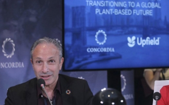 Lawrence Haddad speaking at a conference in front of a blue screen
