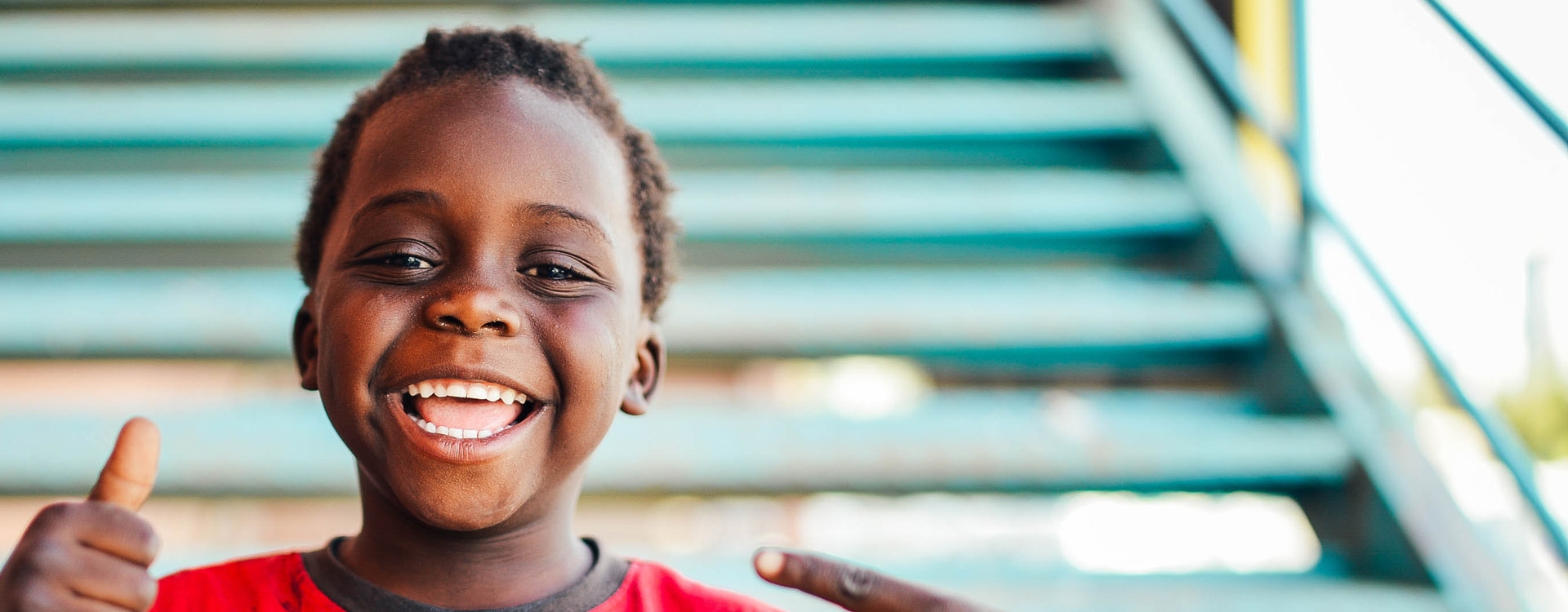 African kid smiling with thumbs up
