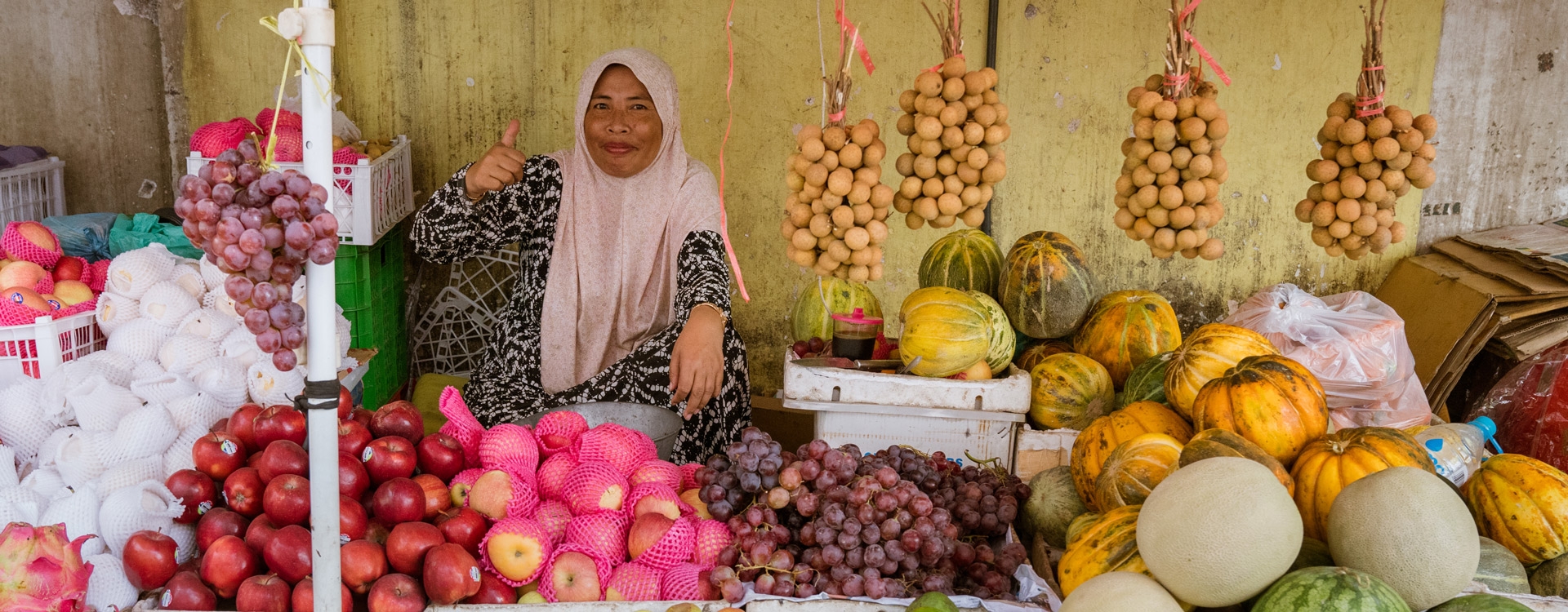 Woman thumbs up market Indonesia