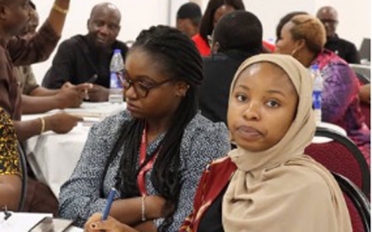Participants in a workshop sitting at a table with water bottles