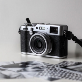 Photo camera close up with photos nearby Photo camera close up with photos nearby