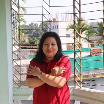 Daina smiling and wearing a red tshirt while embracing