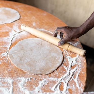 Rolled chapati with hand on the table