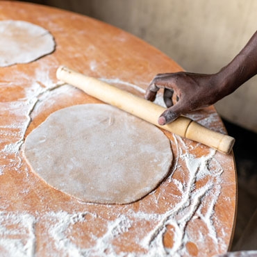 Rolled chapati with hand on the table Rolled chapati with hand on the table