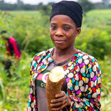 Woman holding a root in her hands and smiling to the camera