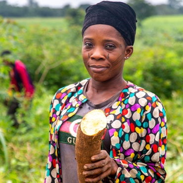 Woman holding a root in her hands and smiling to the camera Woman holding a root in her hands and smiling to the camera