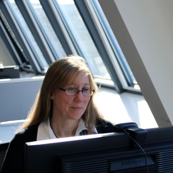 Catherine looking at her laptop and smiling 