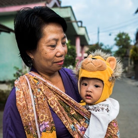 Woman holding baby with lion hat